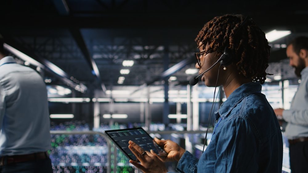 IT specialist monitoring systems on a tablet in a data centre
